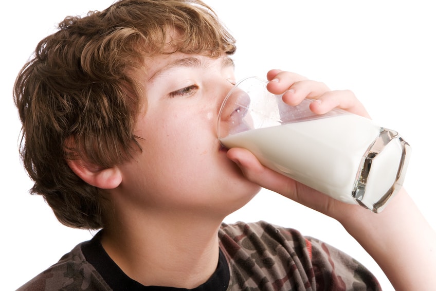 Young boy drinking a glass of milk by hemophiliafed.org